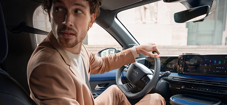 Een man parkeert de nieuwe Lancia Ypsilon. Lancia Glass pakket